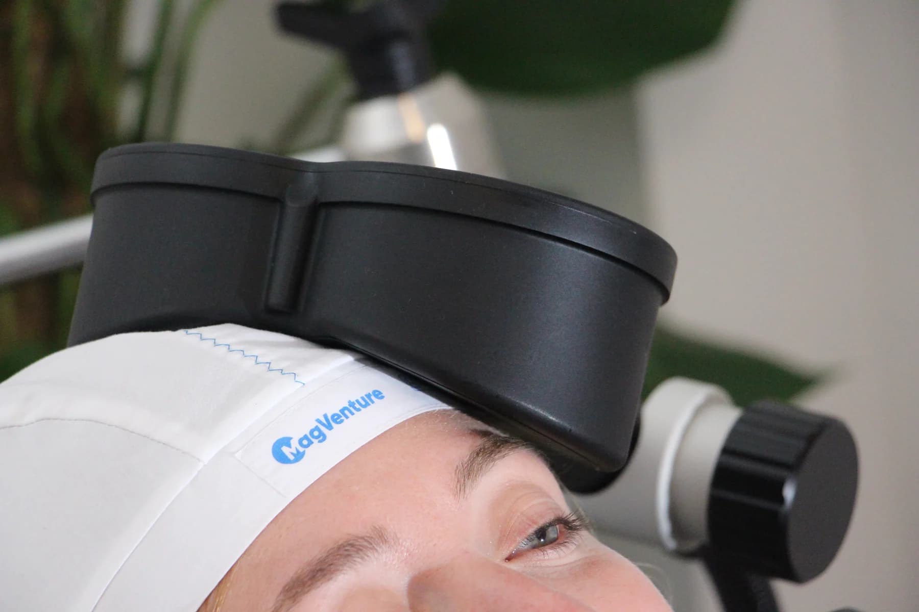 Magnetspule über dem Kopf einer Patientin während der Behandlung